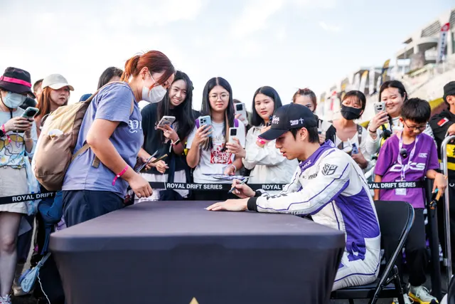 A driver signing autographs